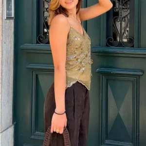 Woman wearing an antique gold vintage-style sequin mesh camisole top with floral beadwork and a scalloped hem